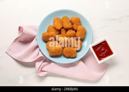 Tasty ketchup and chicken nuggets on marble table, flat lay Stock Photo