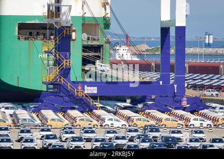 YANTAI, CHINA - 23. AUGUST 2023 - Nutzfahrzeuge werden für den Export über Ro-Ro-Schiffe im Yantai-Hafen in Yantai, Provinz Shandong, China, Augus verschickt Stockfoto