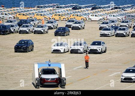 YANTAI, CHINA - AUGUST 23, 2023 - A staff member operates a vehicle intelligent transfer system to move  commodity vehicles at the commercial vehicle Stock Photo