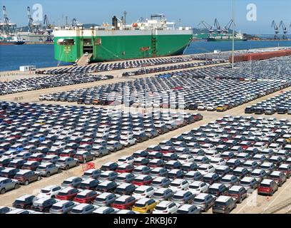 YANTAI, CHINA - 23. AUGUST 2023 - Nutzfahrzeuge werden für den Export über Ro-Ro-Schiffe im Yantai-Hafen in Yantai, Provinz Shandong, China, Augus verschickt Stockfoto