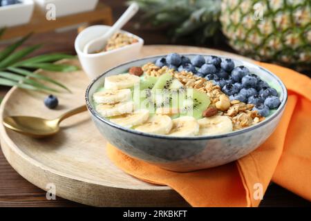 Leckere Smoothie-Schüssel mit frischem Obst und Haferbrei auf dem Tisch Stockfoto