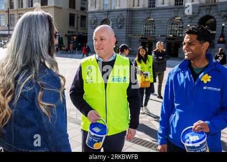 Auckland, Neuseeland, 25. August 2023. Der nationale Parteichef Christopher Luxon (C) und Mahesh Muralidhar, ein Kandidat der Auckland Central, sammeln sich für den Daffodil Day der Cancer Society, während er sich für die Wahlen einsetzt. Quelle: David Rowland/Alamy Live News Stockfoto