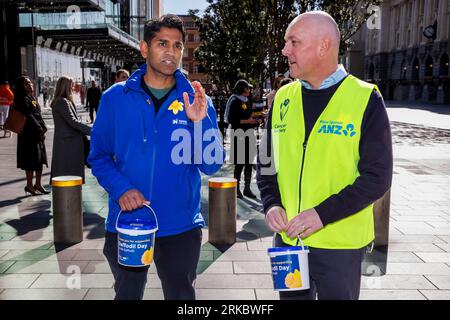 Auckland, Neuseeland, 25. August 2023. Mahesh Muralidhar (L), Kandidat der Auckland Central, mit Christopher Luxon, dem Führer der National Party, sammelt sich für den Daffodil Day der Cancer Society, während er sich für die Wahlen einsetzt. Quelle: David Rowland/Alamy Live News Stockfoto