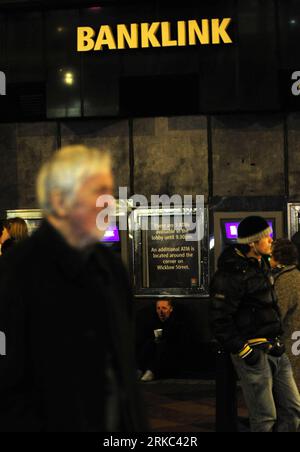 Bildnummer: 54661514  Datum: 20.11.2010  Copyright: imago/Xinhua (101120) -- DUBLIN, Nov. 20, 2010 (Xinhua) -- A woman begs beside ATM machines of the Allied Irish Banks (AIB) in Dublin, Ireland, Nov. 20, 2010. Talks are underway in Dublin between the Irish government and delegations from the European Union, the International Monetary Fund (IMF) and the European Central Bank on a possible tens of billions of euros aid package for the debt-stricken country. (Xinhua/Zeng Yi) (zw) IRELAND-DUBLIN-DEBT CRISIS PUBLICATIONxNOTxINxCHN Wirtschaft Irland Wirtschaftskrise Finanzkrise Banken land leute Ar Stock Photo