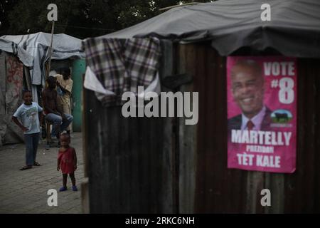 Bildnummer: 54680726  Datum: 26.11.2010  Copyright: imago/Xinhua (101127) -- PORT-AU-PRINCE, Nov. 27, 2010 (Xinhua) -- Haitian children are seen beside a poster of presidential candidate Michel Martelly inside a provisional camp for victims of the January earthquake in Port-au-Prince, Haiti, on Nov. 26, 2010. Haiti will hold presidential election on Nov. 28 amid cholera epidemic that has left at least 1,000 dead. (Xinhua/Str) (axy) HAITI-PRESIDENTIAL ELECTION-POSTERS PUBLICATIONxNOTxINxCHN Politik Wahlen Wahlkampf Haiti premiumd kbdig xsp 2010 quer o0 Präsidentschaftswahl, Wahlkampf, Wahlwerbu Stock Photo