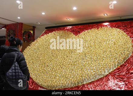 Bildnummer: 54753356  Datum: 15.12.2010  Copyright: imago/Xinhua (101216) -- NANJING, Dec. 16, 2010 (Xinhua) -- A customer looks at a heart-shaped pattern consisting of 1,999 golden roses made by foil of 99.99 percent gold at a gold store in Nanjing, capital of east China s Jiangsu Province, Dec. 15, 2010. The price of the golden rose is 299 RMB yuan (45 US dollars) per item. (Xinhua) (hdt) #CHINA-NANJING-GOLDEN ROSES (CN) PUBLICATIONxNOTxINxCHN Gesellschaft kbdig xkg 2010 quer premiumd o0 Objekte    Bildnummer 54753356 Date 15 12 2010 Copyright Imago XINHUA  Nanjing DEC 16 2010 XINHUA a Custo Stock Photo