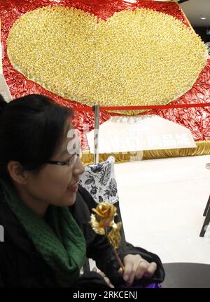 Bildnummer: 54753351  Datum: 15.12.2010  Copyright: imago/Xinhua (101216) -- NANJING, Dec. 16, 2010 (Xinhua) -- An customer holds a golden rose in front of a heart-shaped pattern consisting of 1,999 golden roses made by foil of 99.99 percent gold at a gold store in Nanjing, capital of east China s Jiangsu Province, Dec. 15, 2010. The price of the golden rose is 299 RMB yuan (45 US dollars) per item. (Xinhua) (hdt) #CHINA-NANJING-GOLDEN ROSES (CN) PUBLICATIONxNOTxINxCHN Gesellschaft kbdig xkg 2010 hoch    Bildnummer 54753351 Date 15 12 2010 Copyright Imago XINHUA  Nanjing DEC 16 2010 XINHUA to Stock Photo