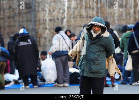 Bildnummer: 54777273  Datum: 30.12.2010  Copyright: imago/Xinhua (101230) -- TOKYO, Dec. 30, 2010 (Xinhua) -- A homeless man tries a jacket at Shinjuku central park in Tokyo, capital of Japan, on Dec. 30, 2010. Members from Japan s social public welfare organizations pitched up tents here in recent days for the homeless and offered them clothes and heated meals twice a day. Besides, many kinds of activities and necessary medical care were prepared for them as well to help them spend the New Year in a smooth manner. The volunteering work is carried out from Dec. 28, 2010 to Jan. 3, 2011. The po Stock Photo