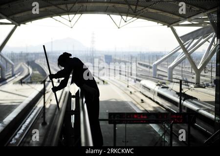 Bildnummer: 54780605  Datum: 31.12.2010  Copyright: imago/Xinhua (101231) -- GUANGZHOU, Dec. 31, 2010 (Xinhua) -- A worker cleans glass at Guangzhou South Railway Station, the departure station of Guangzhou-Zhuhai intercity railway line, in Guangzhou, capital of south China s Guangdong Province, Dec. 31, 2010. The intercity railway line, with the highest speed of 250 km per hour, started trial operation on Friday. It will shorten the travelling time between Guangzhou and Zhuhai to about 40 minutes. (Xinhua/Liang Xu) (mcg) CHINA-GUANGZHOU-ZHUHAI-INTERCITY RAILWAY-TRIAL OPERATION (CN) PUBLICATIO Stock Photo