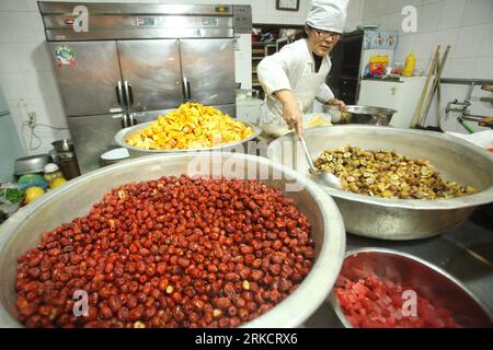 Bildnummer: 54798938  Datum: 11.01.2011  Copyright: imago/Xinhua (110111) -- BEIJING, Jan. 11, 2011 (Xinhua) -- A layman Buddhist prepares raw materials for cooking laba rice porridge in the Guanghua Temple in Beijing, capital of China, Jan. 11, 2011. Chinese have long followed the tradition of eating laba rice porridge, made with local specialties such as ginkgo fruits, chestnuts, lotus seeds and red beans in addition to the rice, on 8th day of the twelfth lunar month. (Xinhua) (zn) #CHINA-LABA FESTIVAL (CN) PUBLICATIONxNOTxINxCHN Gesellschaft traditionelle Feste kbdig xng 2011 quer o0 Küche, Stock Photo