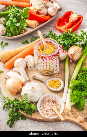 Hausgemachtes Gemüsebrühen-Pulver, Bio-Gemüsebrühe, mit rohem Gemüse, Pilzen und Kräutern Stockfoto
