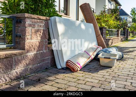 Konzept für den Mülltag, verschiedene Müllartikel, die auf einer Straße für die Sammlung von Großabfällen des rates aufgestellt werden, Sperrmüll und Abfallwirtschaft Stockfoto