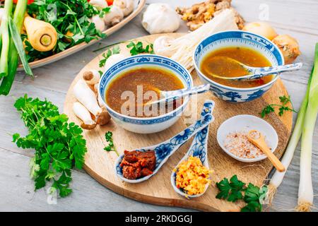 Miso, Ramen oder Gemüsebrühe mit Zutaten auf hölzernem Hintergrund Stockfoto