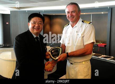 Bildnummer: 54959304  Datum: 25.02.2011  Copyright: imago/Xinhua (110225) -- HONG KONG, Feb. 25, 2011 (Xinhua) -- Captain of the luxury cruise ship Seabourn Sojourn presents a maiden call memorial shield to Anthony Lau (R) , executive director of the Hong Kong Tourism Board, in Hong Kong, south China, Feb. 25, 2011. The luxurious cruise ship Seabourn Sojourn, with a displacement of 32,000 metric tons, entered Hong Kong for the first time on Friday. Anthony Lau, executive director of the Hong Kong Tourism Board, said the Asian cruise line industry has been heating up in the last decade and crui Stock Photo