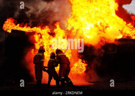 Bildnummer: 54976005  Datum: 03.03.2011  Copyright: imago/Xinhua PESHAWAR, March 3, 2011 (Xinhua) -- Firefighters try to extinguish fire from the burning NATO oil tanker following an explosion in northwest Pakistan s Peshawar on March 3, 2011. Two NATO tankers were caught fire on Thursday when an unexploded timed device went off, wounding two in Peshawar. Militants frequently attack trucks traveling through the Khyber Pass carrying supplies to NATO and US troops in landlocked Afghanistan. (Xinhua/Umar Qayyum) (cl) PAKISTAN-PESHAWAR-ATTACK-RESCUE PUBLICATIONxNOTxINxCHN Gesellschaft Politik Nato Stock Photo