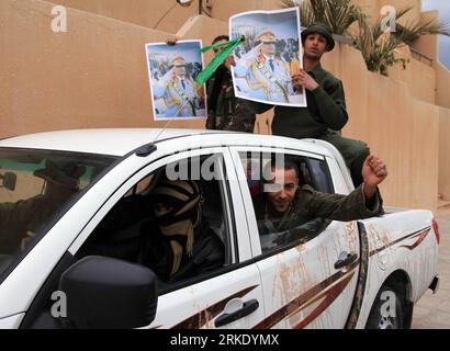 Bildnummer: 55019352  Datum: 12.03.2011  Copyright: imago/Xinhua RAS LANOUF (LIBYA), March 13, 2011 (Xinhua) -- show their loyalty to xGaddafix in Ras Lanouf, about 615 kilometers east of Tripoli, capital of Libya, on March 12, 2011. Soldiers loyal to xGaddafix escorted a convoy of media vehicles into Ras Lanouf on Saturday. The town of Ras Lanuf, where the largest of Libya s five refineries are located, was in government s control on Saturday after days of bombardment forcing occupying rebels to retreat overnight. (Xinhua/Hamza Turkia) (lr) LIBYA-RAS LANOUF-GOVERNMENTAL TOUR FOR FOREIGN MEDIA Stock Photo