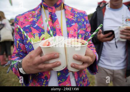 Dateifoto vom 25/06/2017 von einem Mann, der Cocktails beim Glastonbury Festival, Worthy Farm, Somerset hält. So genannte „umweltfreundliche“ Trinkhalme aus Papier enthalten langlebige und potenziell toxische Chemikalien und sind möglicherweise nicht besser für die Umwelt als Kunststoffversionen, warnten Forscher. Belgische Forscher fanden heraus, dass in 18 von 20 Papierhalmmarken langlebige „für immer gefährliche Chemikalien“ gefunden wurden, die potenziell für Menschen, Wildtiere und die Umwelt schädlich sind. Ausgabedatum: Freitag, 25. August 2023. Stockfoto