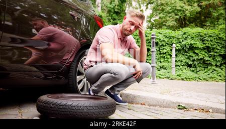 Fahrzeug Mit Platten Reifen. Ein Mann Am Telefon Stockfoto