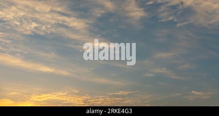 Ein fesselndes Foto fängt den ruhigen Abendhimmel ein, während die absteigende Sonne die Welt in ein warmes, goldenes Licht taucht. Die Farben des Himmels sind atemberaubend Stockfoto