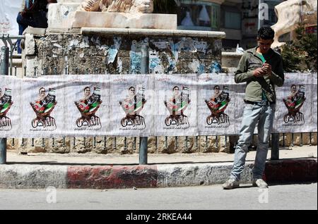 Bildnummer: 55157018  Datum: 30.03.2011  Copyright: imago/Xinhua RAMALLAH, March 30, 2011 (Xinhua) -- A Palestinian man stands in front of a poster commemorating Land Day in the West Bank city of Ramallah, on Land Day, March 30, 2011. The Palestinians mark March 30 as the Land Day to remember the deaths of six Arabs in the hands of Israeli forces when they were protesting the annexation of Palestinian land in 1976. (Xinhua/Chen Xu) (msq) MIDEAST-RAMALLAH-LAND-DAY PUBLICATIONxNOTxINxCHN Gesellschaft Politik Protest Demo Palästina kbdig xcb 2011 quer    Bildnummer 55157018 Date 30 03 2011 Copyri Stock Photo