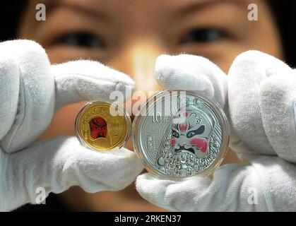 Bildnummer: 55277532  Datum: 19.04.2011  Copyright: imago/Xinhua (110420) -- SUZHOU, April 20, 2011 (Xinhua) -- A staff shows the second set of gold and silver commemorative coins featuring traditional Peking Opera facial makeup in Suzhou, east China s Jiangsu Province, April 19, 2011. The People s Bank of China issued Tuesday a second set of gold and silver coins commemorative coins featuring traditional Peking Opera facial makeup in Suzhou. The new commemorative series consist of one gold coin with one quarter of an ounce and two silver coins containing an ounce each, which will be put on sa Stock Photo