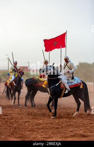 Essaouira, Marokko - 13. August 2023: Reiterinnen und Reiter nehmen an einer traditionellen Kostümveranstaltung namens Tbourida Teil, die in einem traditionellen marokkanischen Stil gekleidet ist Stockfoto