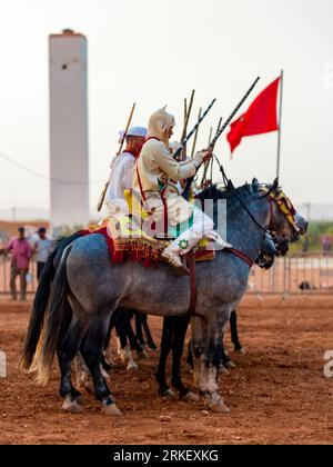 Essaouira, Marokko - 13. August 2023: Reiterinnen und Reiter nehmen an einer traditionellen Kostümveranstaltung namens Tbourida Teil, die in einem traditionellen marokkanischen Stil gekleidet ist Stockfoto