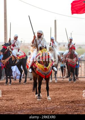 Essaouira, Marokko - 13. August 2023: Reiterinnen und Reiter nehmen an einer traditionellen Kostümveranstaltung namens Tbourida Teil, die in einem traditionellen marokkanischen Stil gekleidet ist Stockfoto