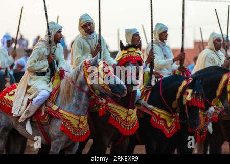 Essaouira, Marokko - 13. August 2023: Reiterinnen und Reiter nehmen an einer traditionellen Kostümveranstaltung namens Tbourida Teil, die in einem traditionellen marokkanischen Stil gekleidet ist Stockfoto