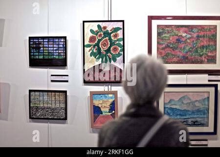 Bildnummer: 55324794  Datum: 07.05.2011  Copyright: imago/Xinhua (110507) -- PARIS, May 7, 2011 (Xinhua) -- A woman looks at paintings by female French painter Florence Cassez during an exhibition in Paris, France, May 7, 2011. Florence Cassez was sentenced to 60 years in jail by a Mexican court for her part in three kidnappings. France requested to have Cassez serve her 60-year sentence in France rather than in Mexico, under the terms of the Strasbourg Convention signed by the European Union, Mexico, the United States and others in 1983. (Xinhua/Gao Lei) FRANCE-FLORENCE CASSEZ-EXHIBITION PUBL Stock Photo