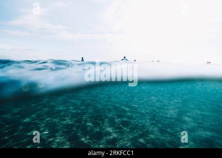 Wir sind unter den Surfern zurückgezogen, die auf dem Surfbrett sitzen Stockfoto