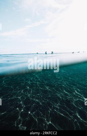 Wir sind unter den Surfern zurückgezogen, die auf dem Surfbrett sitzen Stockfoto