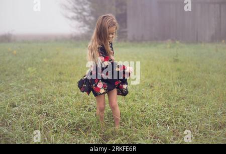 Das junge Mädchen tanzt anmutig allein im Morgennebel Stockfoto