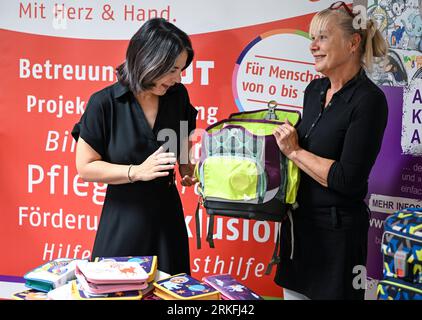 Potsdam, Germany. 25th Aug, 2023. Annalena Baerbock (l, Bündnis 90/Die Grünen), Foreign Minister, and Angela Schweers, Chairwoman of the Board of AWO Potsdam, hand over the schoolbags collected this summer at the 'Kinderland' daycare center. The state program 'Kiez-Kita - opening up educational opportunities' supports children and their families in different family and social situations. Credit: Jens Kalaene/dpa/Alamy Live News Stock Photo