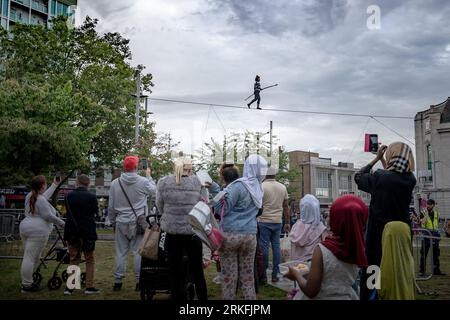 London, Großbritannien. August 2023. GDIF: Die international bekannte Seilwandererin Tatiana Mosio Bongongonga überquert den General Gordon Square in Woolwich und eröffnet 2023 das Greenwich+Docklands International Festival (GDIF). Das atemberaubende Spektakel von Open Lines feiert den Akt des furchtlosen Optimismus mit der Bedeutung des kollektiven Bemühens, Zusammengehörigkeit und Hoffnung zu schaffen. Guy Corbishley/Alamy Live News Stockfoto
