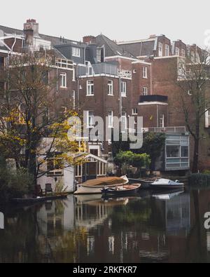 Amsterdam, Netherlands - November 27 2022: The back of Amsterdam houses next to a canal on a misty autumn day. Stock Photo