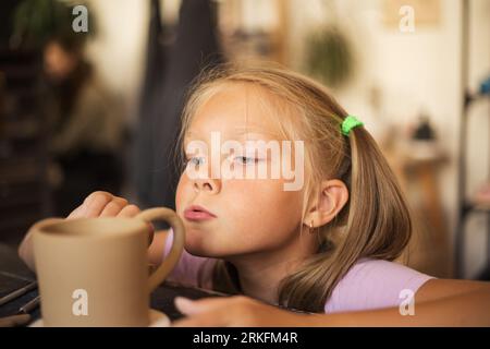 Porträt eines mit Keramik arbeitenden Mädchens in der modernen Töpferei wor Stockfoto