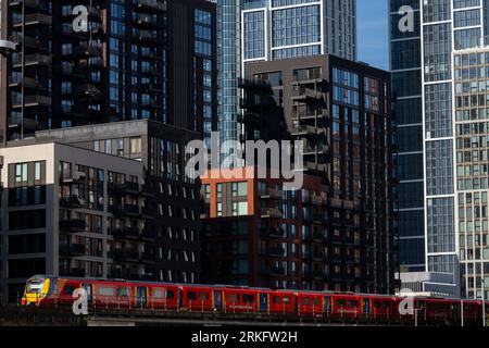 Ein Zug der Southwest Railways, der an neu errichteten Turmblöcken in Nine Elms, South London vorbeifährt. Die Turmblöcke sind Teil einer größeren Sanierung Stockfoto