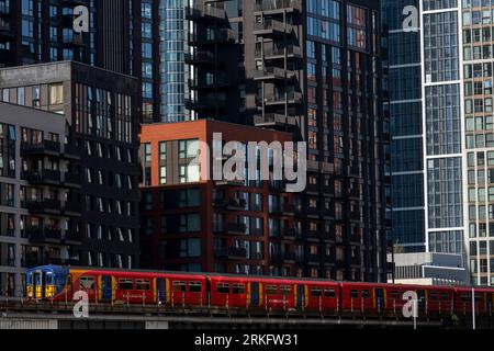 Ein Zug der Southwest Railways, der an neu errichteten Turmblöcken in Nine Elms, South London vorbeifährt. Die Turmblöcke sind Teil einer größeren Sanierung Stockfoto