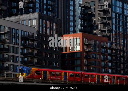 Ein Zug der Southwest Railways, der an neu errichteten Turmblöcken in Nine Elms, South London vorbeifährt. Die Turmblöcke sind Teil einer größeren Sanierung Stockfoto