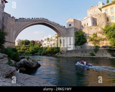 Schnellboote auf dem Fluss Neretva mit Touristen auf Stari Most (Alte Brücke) in Mostar, Bosnien und Herzegowina, 20. August 2023. Stockfoto