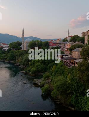 Altstadt am Fluss Neretva mit der Koski Mehmed Pascha Moschee in Mostar an einem Sommerabend, Bosnien und Herzegowina, 20. August 2023. Stockfoto