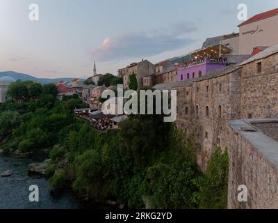 Historische Altstadt am Hügel neben dem Fluss Neretva in der Stadt Mostar an einem Sommerabend, Bosnien und Herzegowina, 20. August 2023. Stockfoto