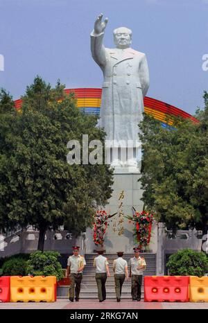 (110630) --ZHENGZHOU, 30. Juni 2011 (Xinhua) -- Wachposten entlasten am Fuß der Statue von Mao Zedong auf dem Hauptplatz des Nanjie Village, im Linying County der zentralchinesischen Provinz Henan, am 28. Juni 2011. Es ist anders als alle anderen Orte in China im Nanjie Village. Am Eingang von Nanjie endet eine breite und gerade Straße am Hauptplatz des Dorfes, wo noch immer eine gigantische weiße Marmorstatue des verstorbenen Vorsitzenden Mao Zedong in der Mitte steht. (Xinhua/Wang Song) (wx) CHINA-HENAN-NANJIE VILLAGE (CN) PUBLICATIONxNOTxINxCHN Stockfoto