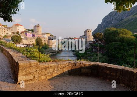 Stari Most (Alte Brücke) über den Neretva Fluss in Mostar mit Bergrecht, Bosnien und Herzegowina, 22. August 2023. Stockfoto