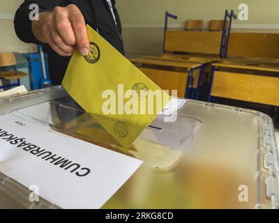 Bursa, Türkei - 28. Mai 2023: Nahaufnahme einer Hand eines Mannes, der während der Wahlen in der Türkei ihre Stimme in eine Wahlurne wirft. Hochwertige Fotos Stockfoto