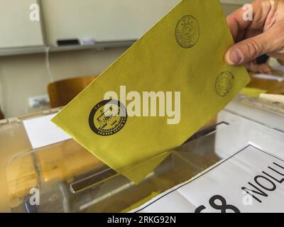 Bursa, Türkei - 28. Mai 2023: Nahaufnahme einer Hand eines Mannes, der während der Wahlen in der Türkei ihre Stimme in eine Wahlurne wirft. Hochwertige Fotos Stockfoto