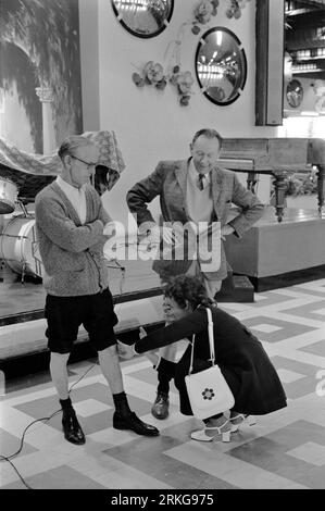 Butlins Holiday Camp, 1970er Jahre Großbritannien. Zwei Männer mit hochgekrempelten Hosenbeinen nehmen am besten und feststen Wettkampf der Wadenmuskulatur Teil. Ein Richter spürt die Beinmuskulatur des Mannes. Bognor Regis, West Sussex, England 1972. HOMER SYKES Stockfoto