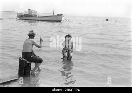 Älteres Paar Ein The Seaside 1960s UK. Auf Strandhaaren sitzen und die ankommende Flut ignorieren, ein Paar diskutiert einige der feineren Punkte des Lebens. Southend on Sea, Essex, England 1969. HOMER SYKES Stockfoto