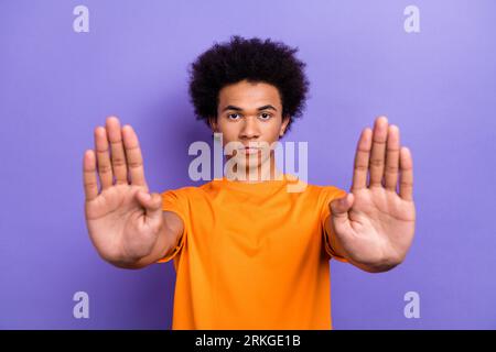 Porträt des ernsten Gesichts Guy Chevelure Haarschnitt zwei Arme Protest gegen Diskriminierung in der Universität isoliert auf violettem Hintergrund Stockfoto